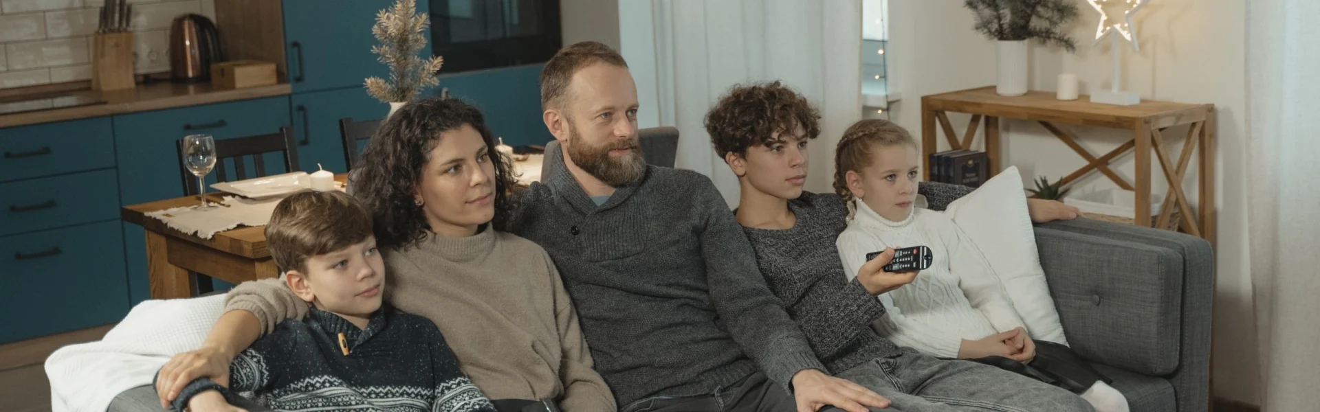 Sammenbragt familie med tre børn sidder i sofa